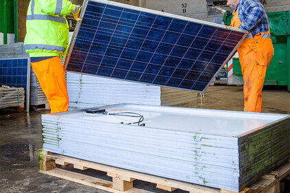 Entsorgung alter PV-Module Zwei Personen bei der Entsorgung alter PV-Module